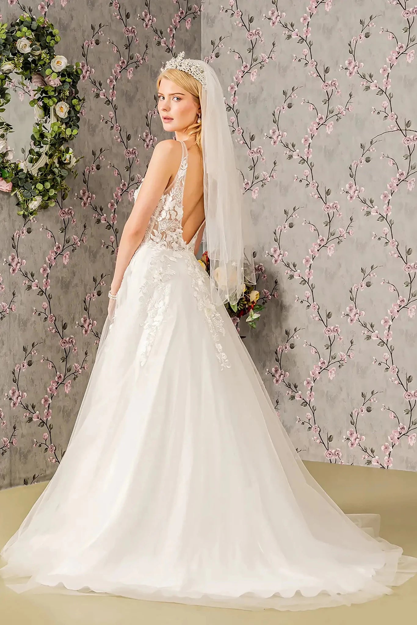 Back full-length view showcasing the classic A-line silhouette and the graceful, expansive sweep of the white fabric extending into the train.