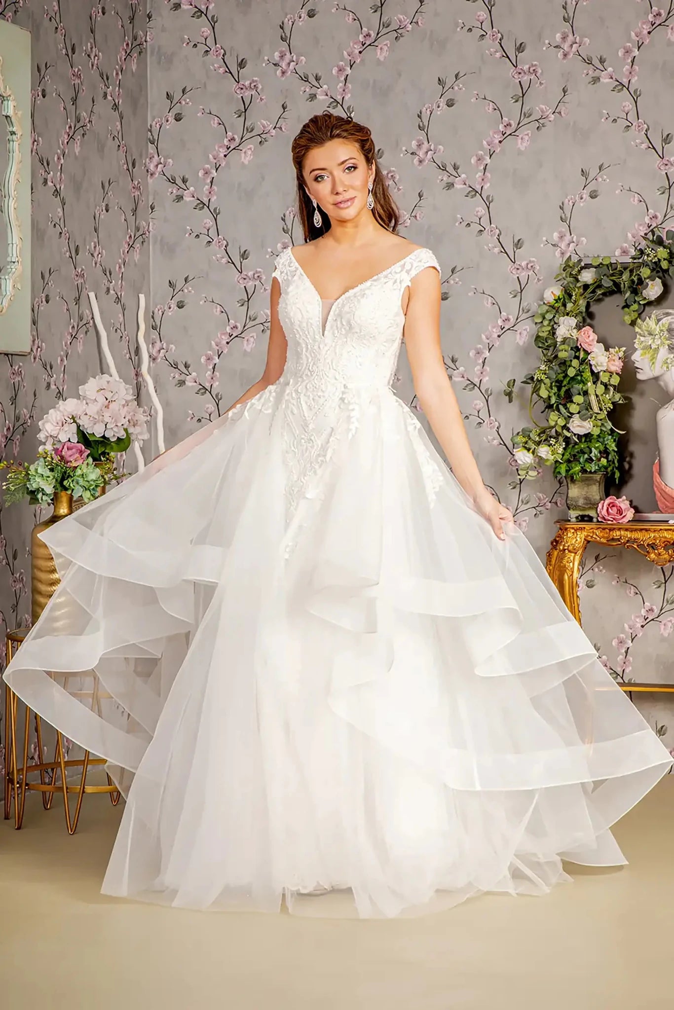 Front full-length view of an ivory mermaid wedding dress featuring an illusion sweetheart neckline, supportive straps, and a detachable layered waist drape that adds a voluminous overskirt effect.