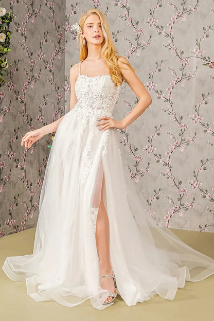 Front full-length view of an ivory A-line wedding dress featuring a clean straight-across neckline, delicate beaded spaghetti straps, and a voluminous layered skirt.