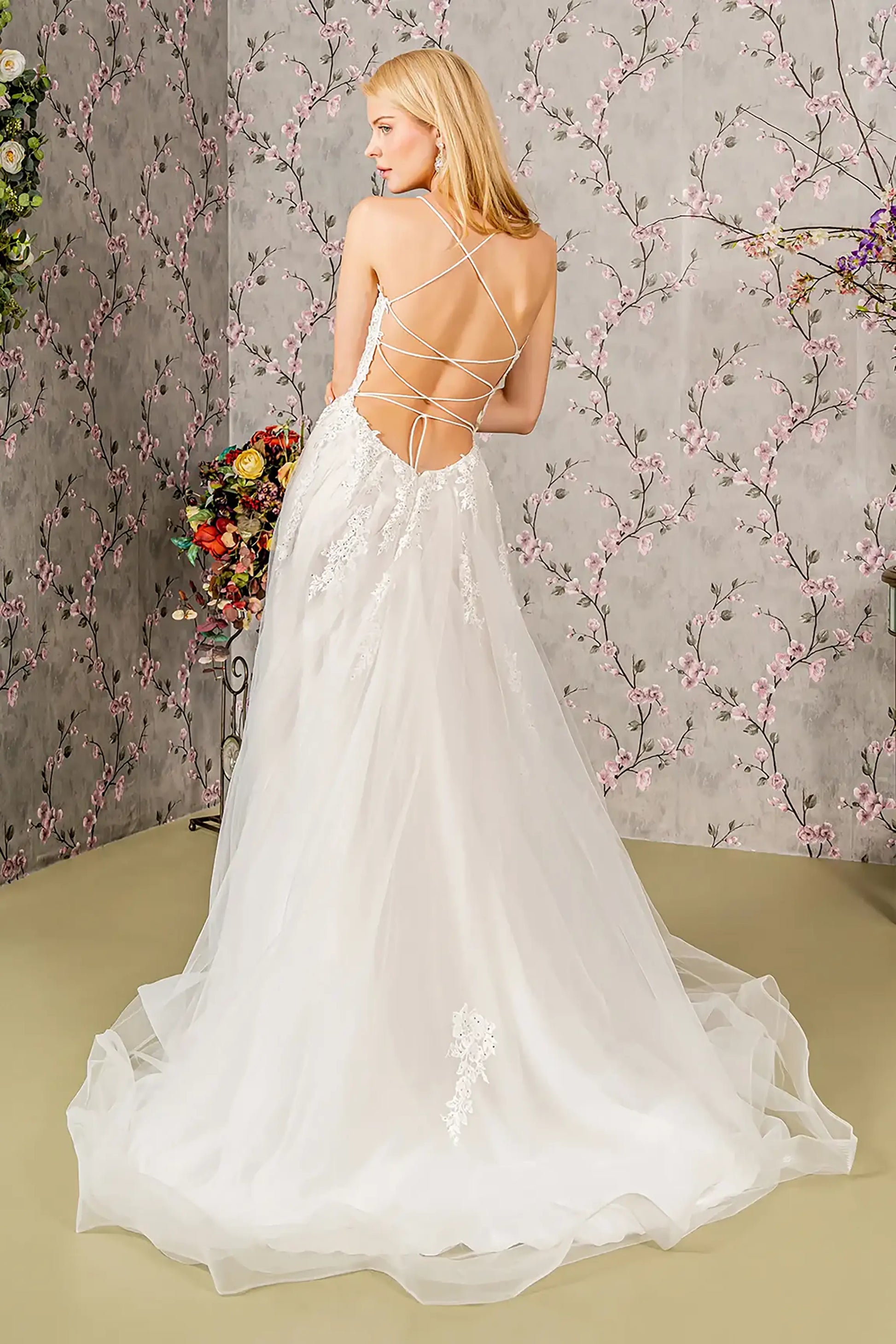 Back full-length view showcasing the graceful A-line silhouette and the expansive sweep of the ivory train, accented with cascading embroidered motifs and fine glitter.