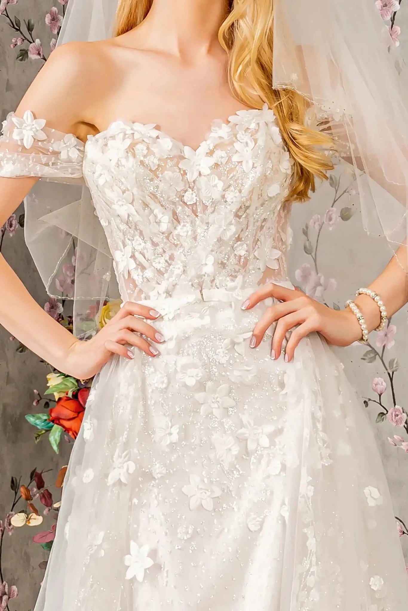 Front close-up upper view highlighting the intricate jeweled floral patterns and sparkling glitter accents that decorate the translucent off-shoulder sleeves and the romantic sweetheart bodice.