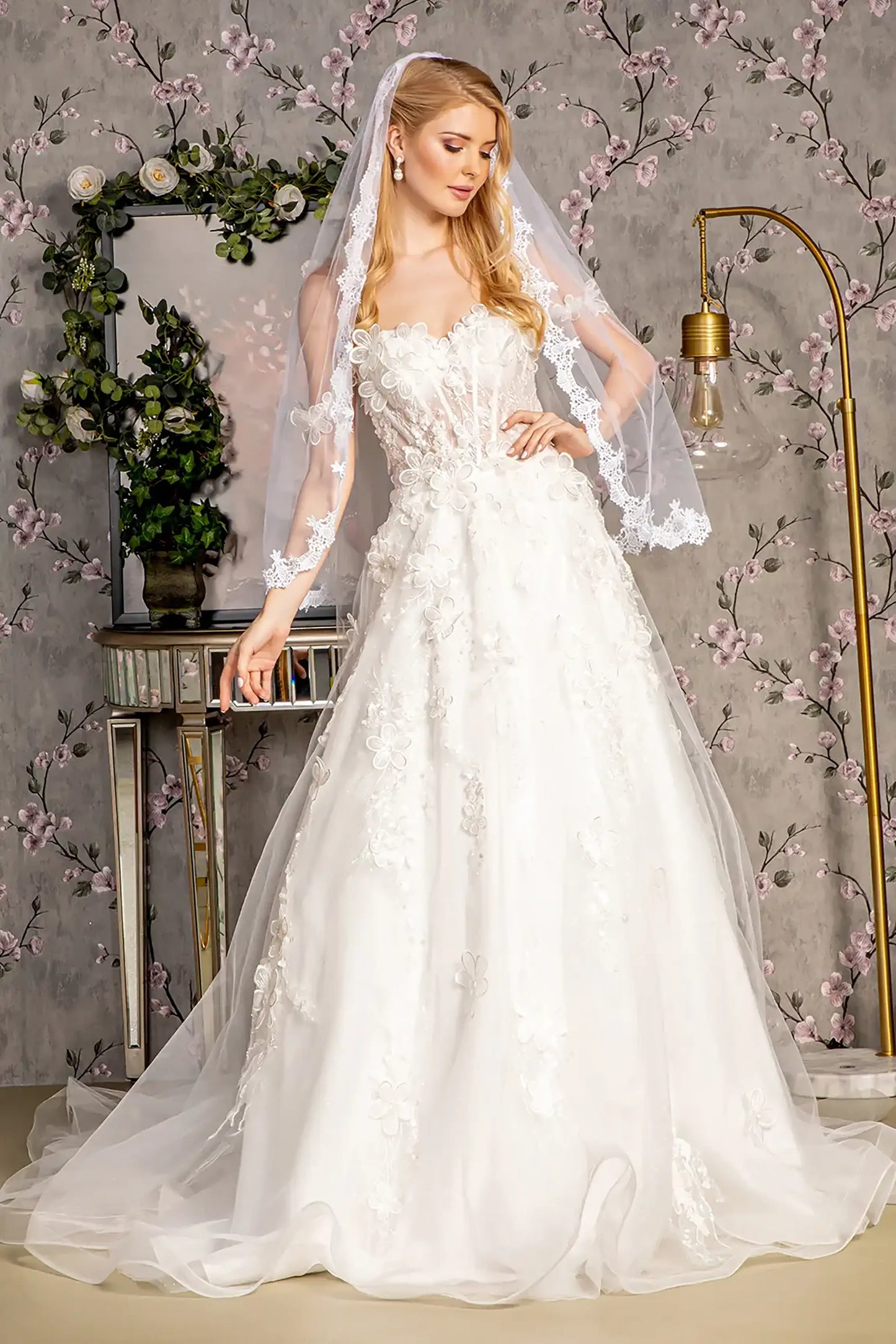 Front full-length view of an ivory A-line wedding dress featuring an illusion sweetheart neckline and a sleeveless, strapless-style bodice.