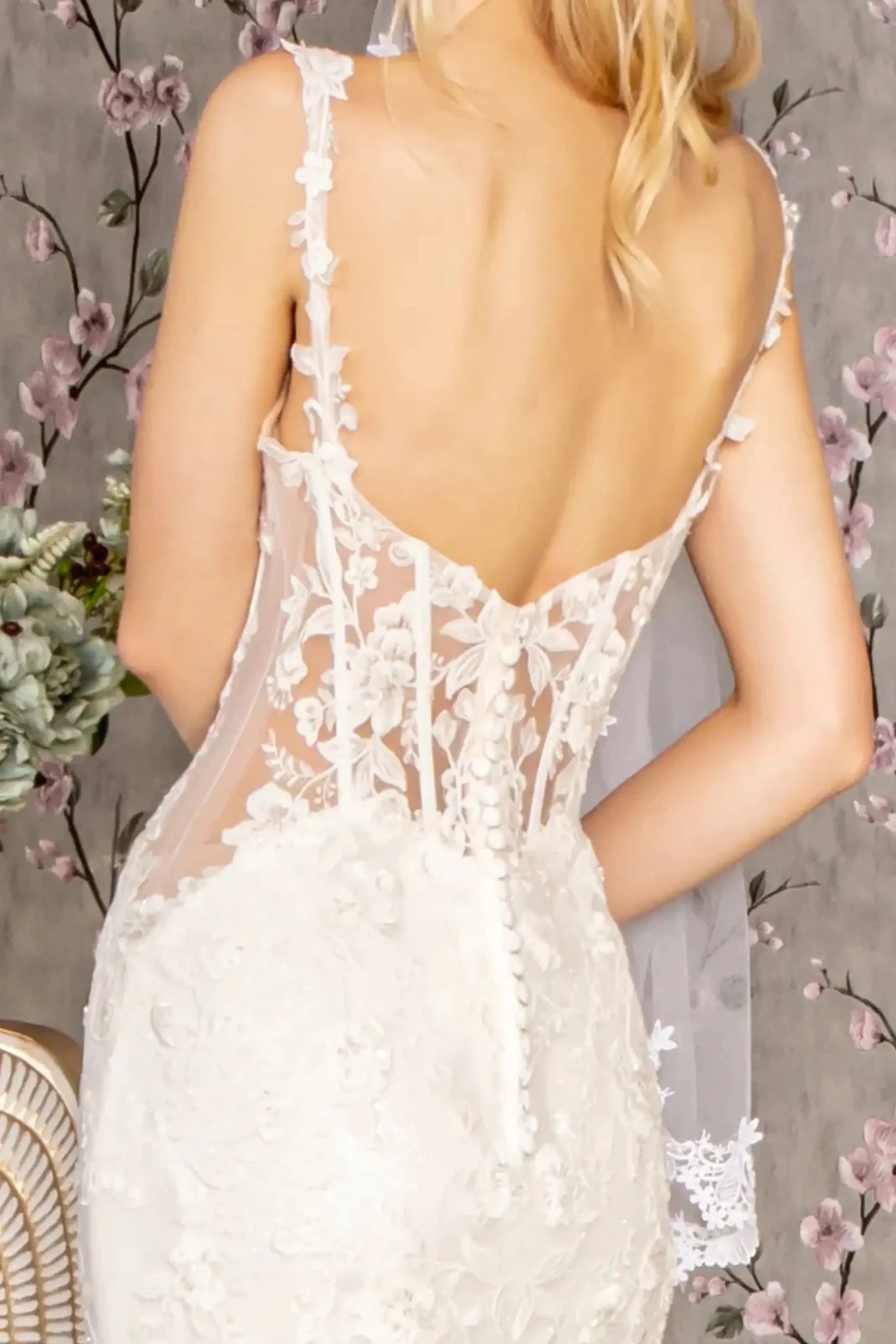 Back close-up upper view focusing on the elegant open back design, secured by a central zipper and a decorative row of traditional button closures.