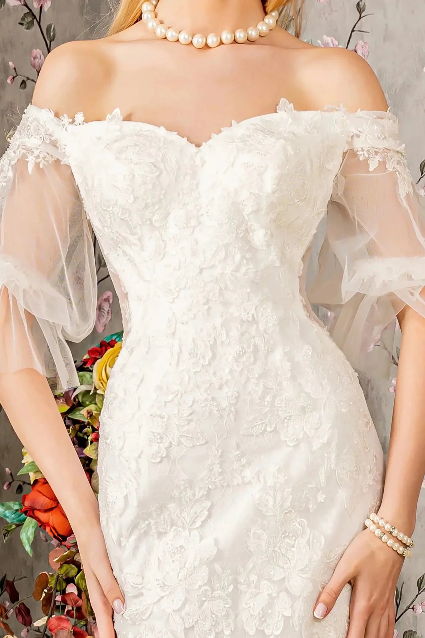Front close-up upper view highlighting the intricate floral embroidery and delicate beadwork decorating the sweetheart bodice and the soft texture of the translucent short sleeves.