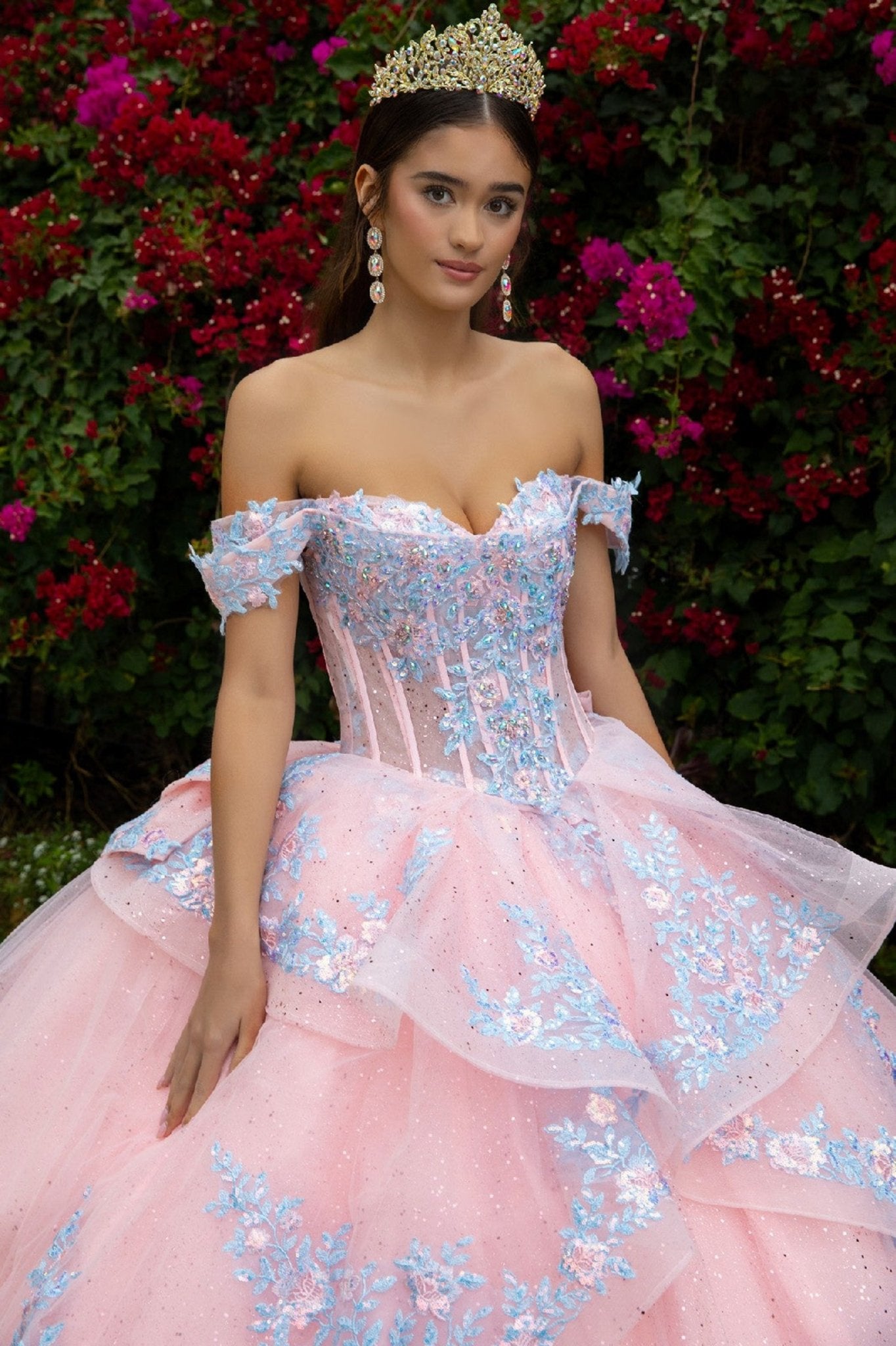 girl wearing a Blush quince Ball Gown with blue, pink embroidery