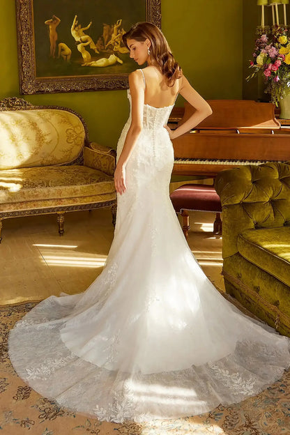 Back full-length view showcasing the contoured trumpet silhouette and the dramatic sweep of the floral lace underlayer extending into the train.