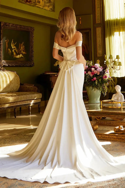 Back full-length view showcasing the sleek silhouette of the fitted gown and the soft extension of the floor-length bridal train.