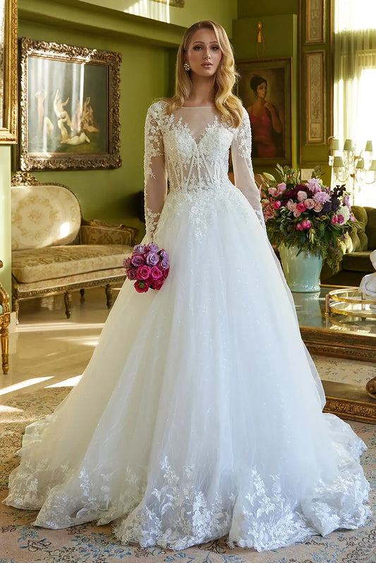 Front full-length view of an off-white A-line wedding dress featuring an illusion V-neckline, long mesh sleeves, and a beaded embroidered corset bodice with a scallop-edged train.