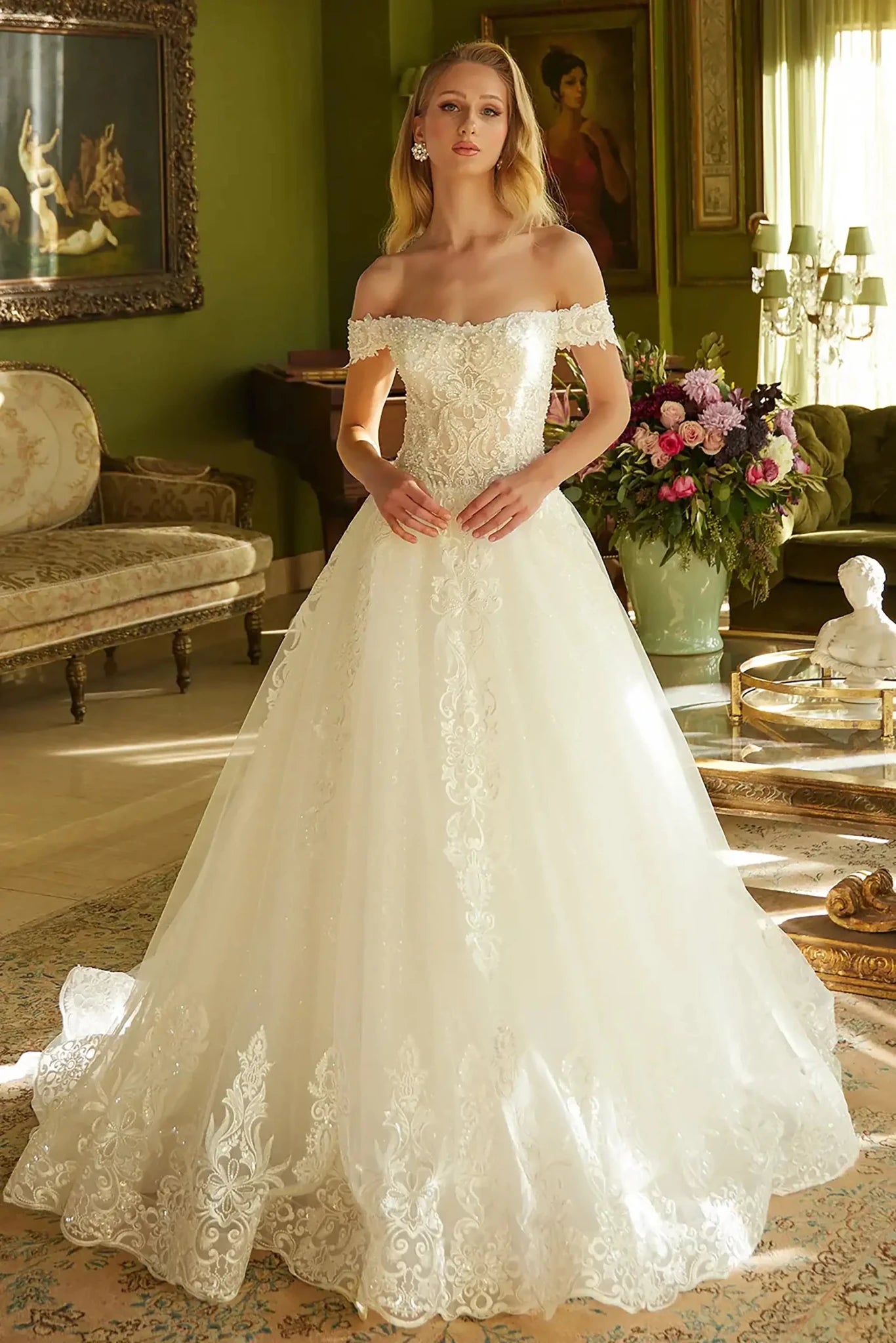 Front full-length view of an off-white A-line wedding dress featuring a sweetheart neckline, beaded embroidered bodice, and a sparkling sequined mesh train.