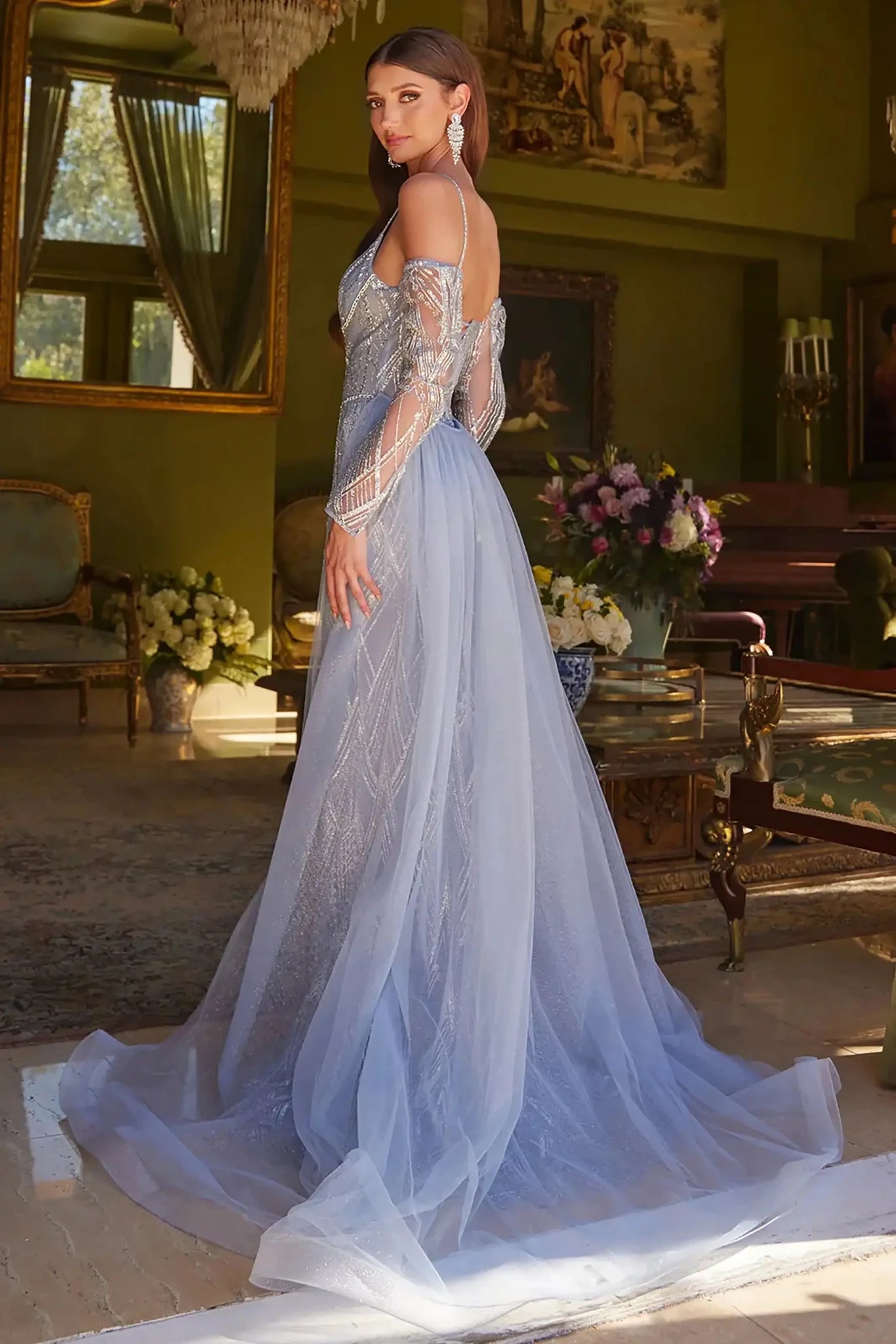 Back full-length view of of a  Smoky blue jeweled fitted prom dress with detachable sleeves and tulle overskirt
