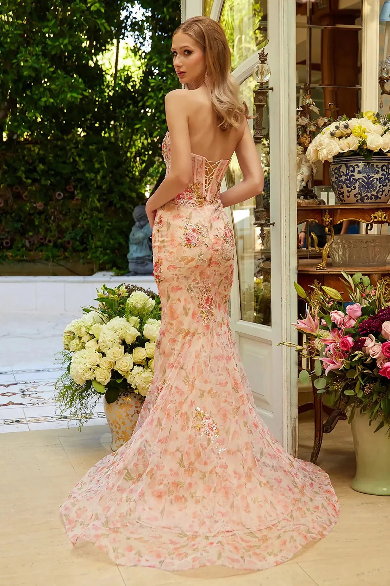 Back full-length view of of a  Peach strapless floral applique prom dress with sweetheart corset bodice
