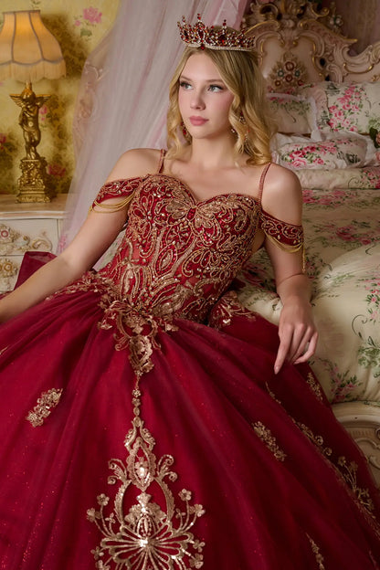 Close-up front view of burgundy quinceañera ball gown showing detailed gold embroidery, beaded corset bodice, off-the-shoulder straps, and glitter tulle skirt