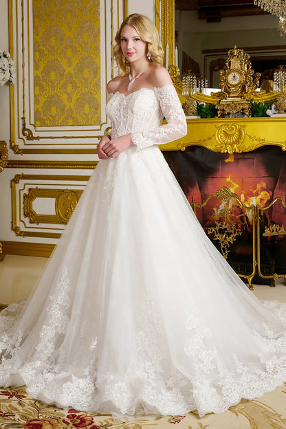 Woman in a white wedding dress standing in an ornate room with gold accents.