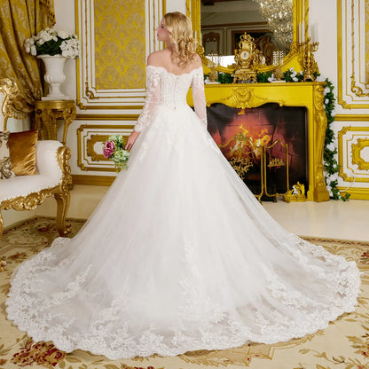 Woman in a white wedding dress standing in an opulent room with gold decor.