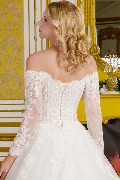 Woman wearing a white lace wedding dress in an elegant room with yellow walls.