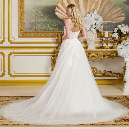 Woman in a white wedding dress standing in an ornate room with gold accents and decorative elements.