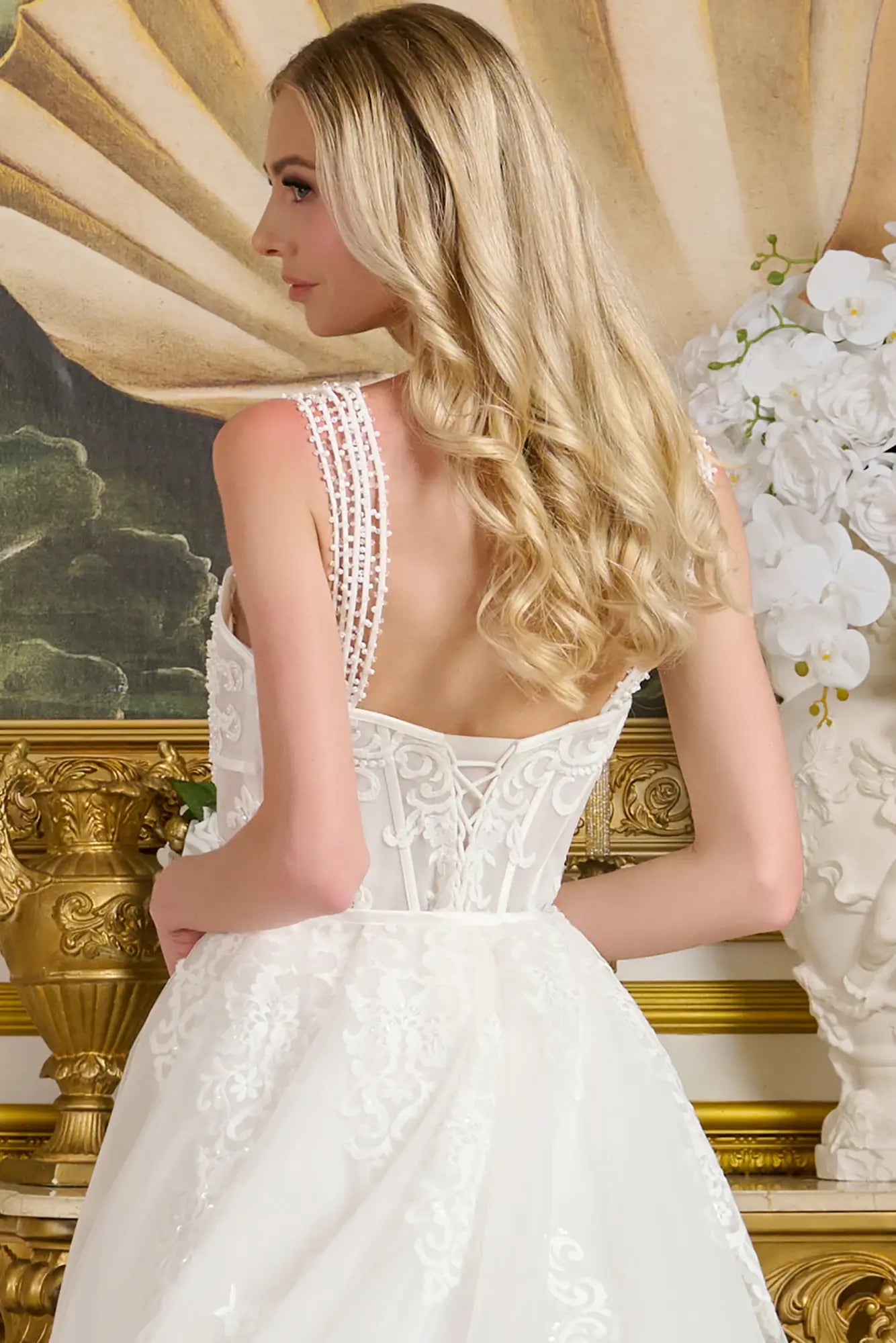 Woman in a white lace wedding dress with a gold decorative background