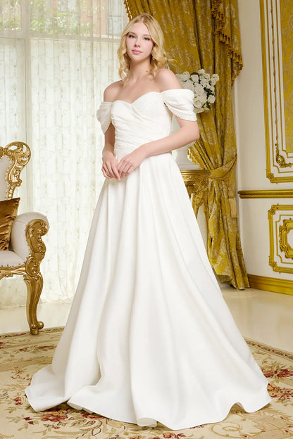 Woman in a white wedding dress standing in an elegant room with gold accents.