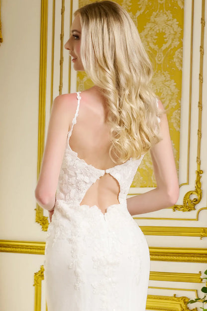 Woman wearing a white lace dress with a gold decorative wall in the background