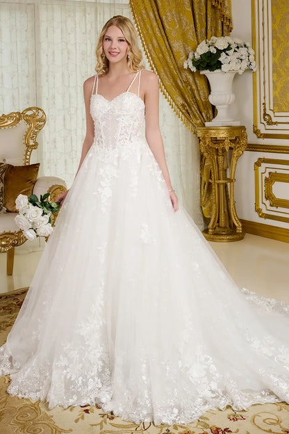 Woman in a white wedding dress standing in an opulent room with gold decor.