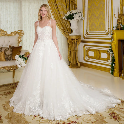 Woman in a white wedding dress standing in an ornate room with gold accents.