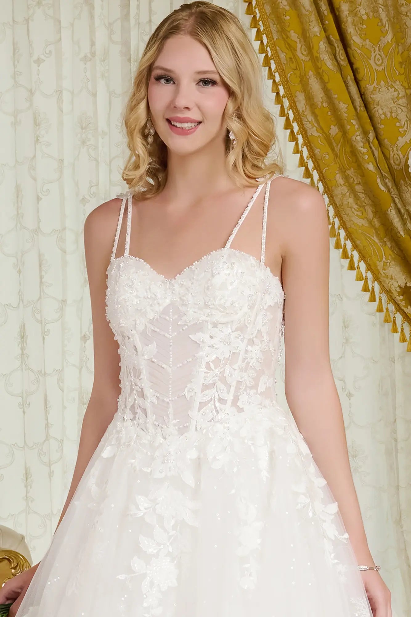 Woman wearing a white lace wedding dress in a decorated room.