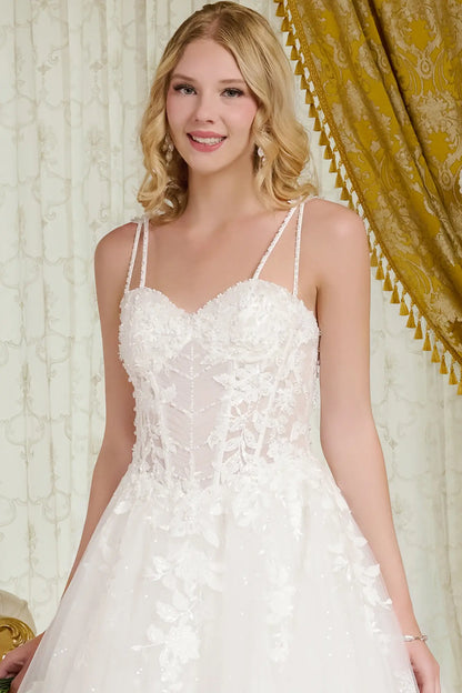 Woman wearing a white lace wedding dress in a decorated room.
