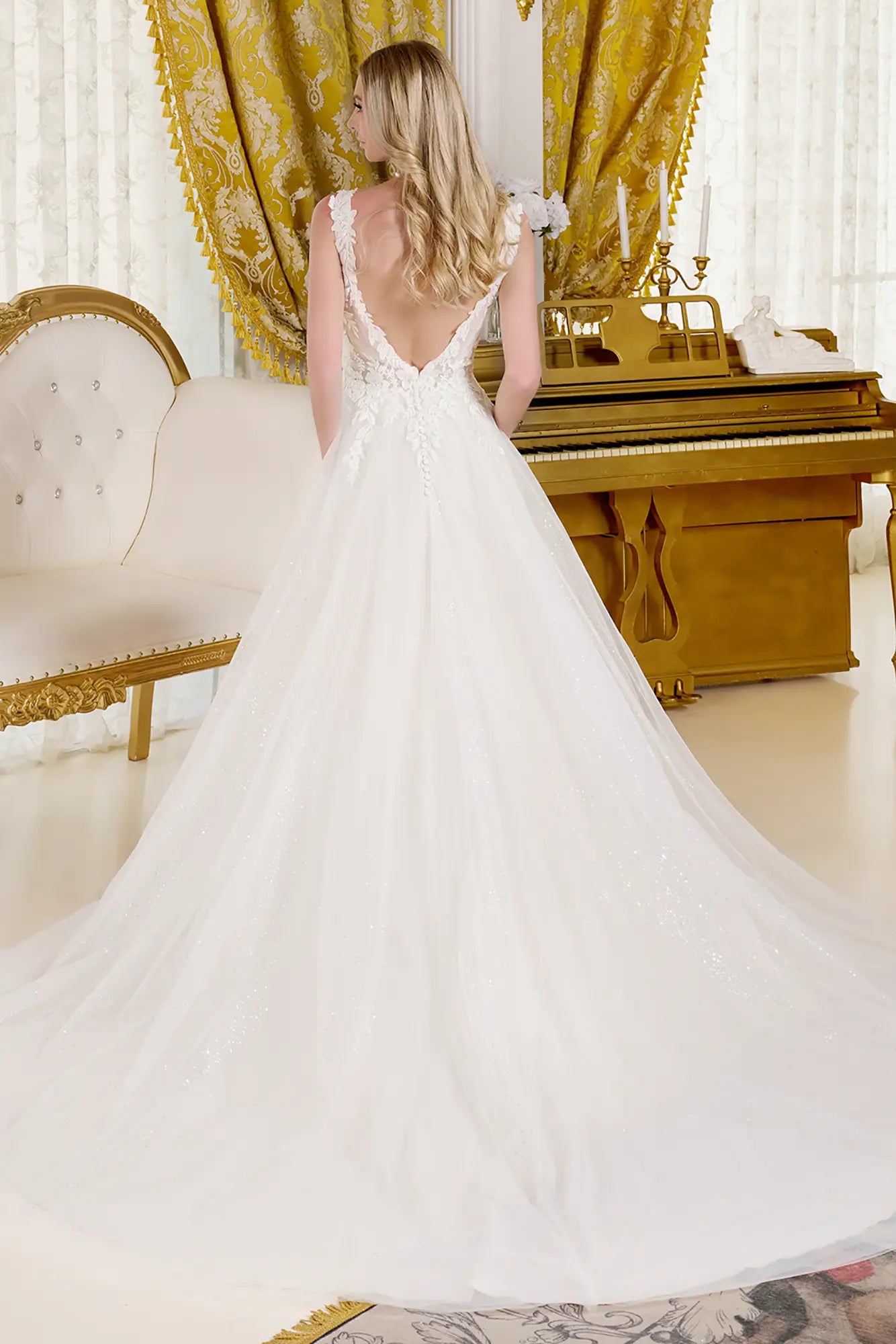 Beautiful back view of the woman wearing a wedding gown in an opulent room settings.