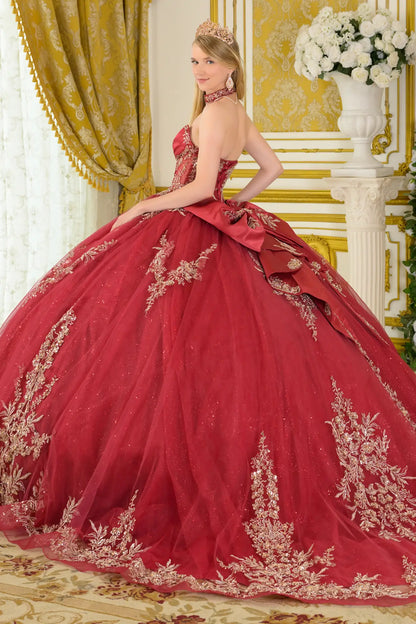 Side back view of burgundy quinceañera ball gown featuring strapless corset, gold embroidery, oversized detachable bow, and full layered tulle skirt