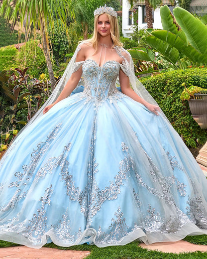 Woman in a light blue ball gown with silver embellishments in a garden setting