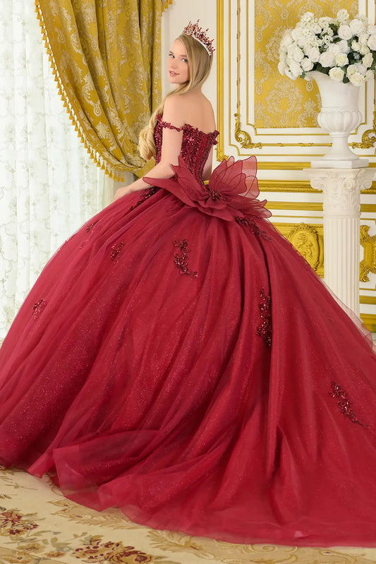 Girl wearing a burgundy quinceañera dress with satin-decorated bodice with intricate detailing in an elegant room.