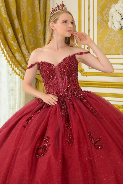 Girl wearing a burgundy quinceañera dress with satin-decorated bodice with intricate detailing in an elegant room.