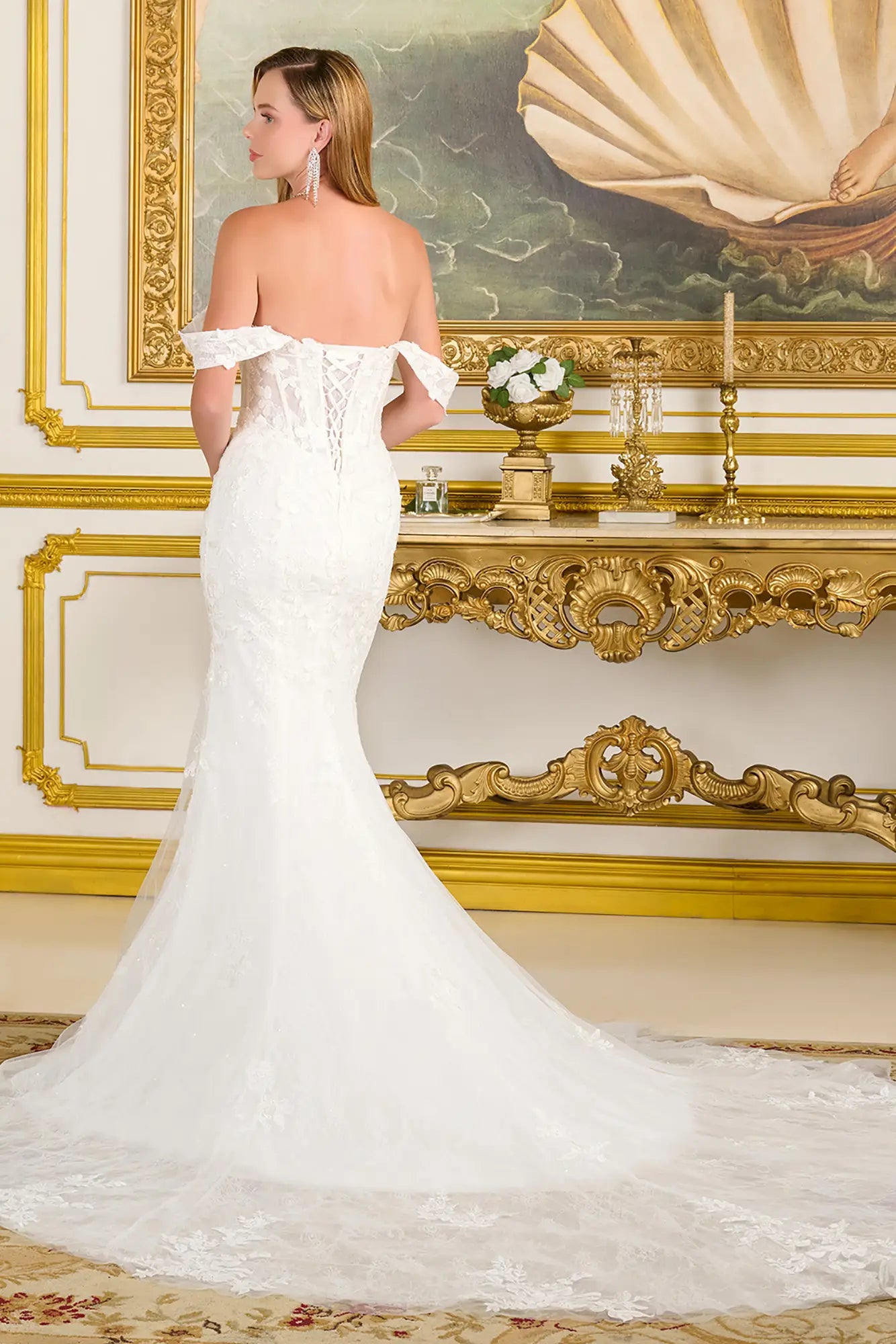 Woman wearing a wedding gown in a gold and white accent room