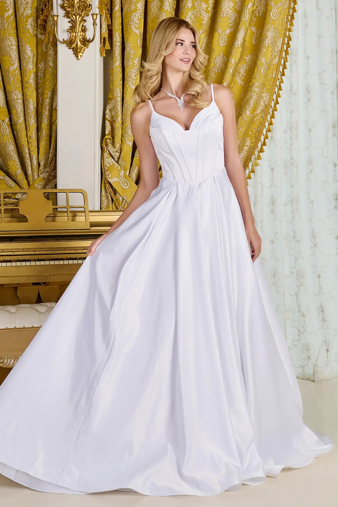 Woman wearing a wedding gown with V-neck corset bodice, spaghetti straps, pleated detailing, Basque waistline, and flowing skirt with soft box pleats.