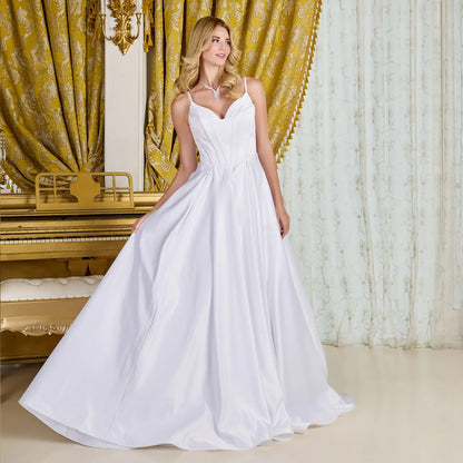 Woman in wedding gown with V-neck corset bodice, spaghetti straps in an elegant room