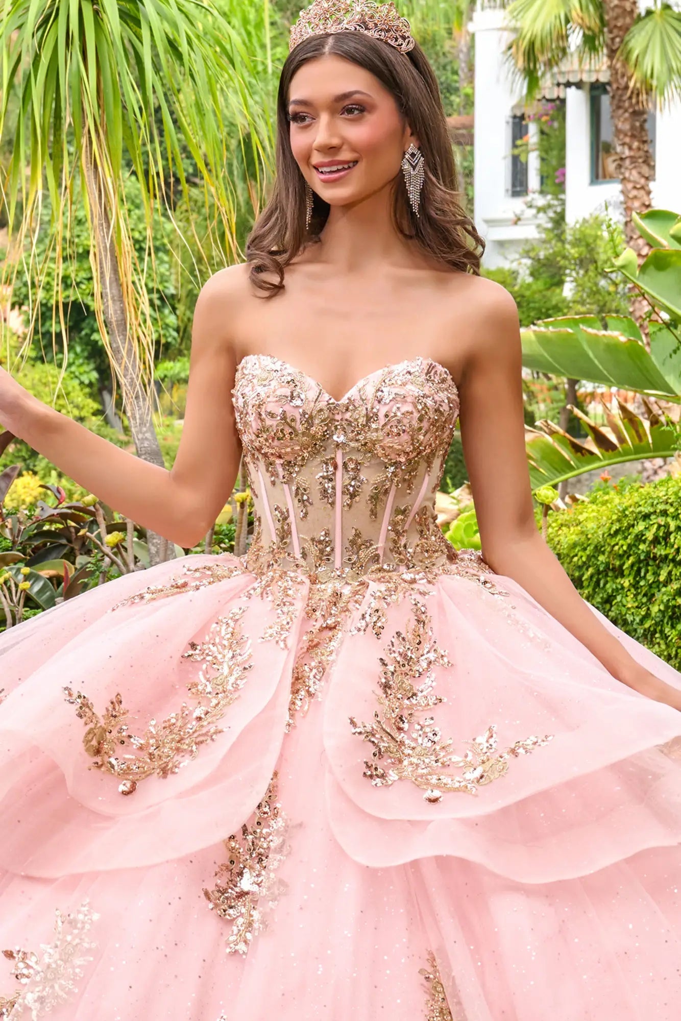 Close-up front detail of blush pink quinceañera dress showing sweetheart neckline, fitted corset, and intricate gold beadwork