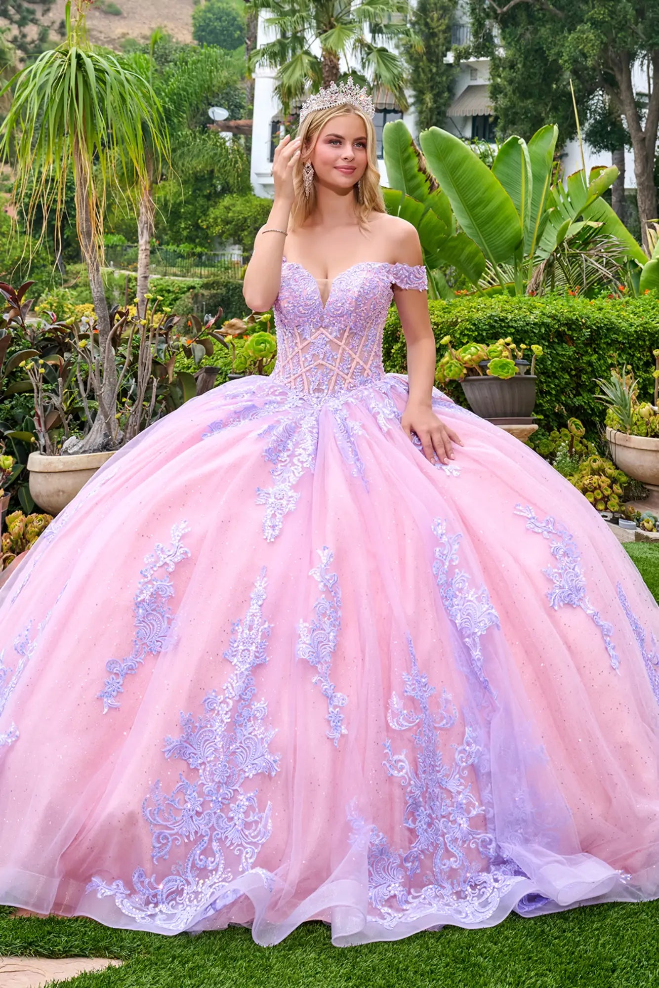 Front view of lilac quinceañera ball gown with off-the-shoulder neckline, corset bodice, and voluminous tulle skirt with embroidered lace details.