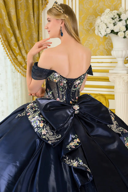 Girl in an elegant navy quinceañera dress floral embroidery in an elegant interior setting.
