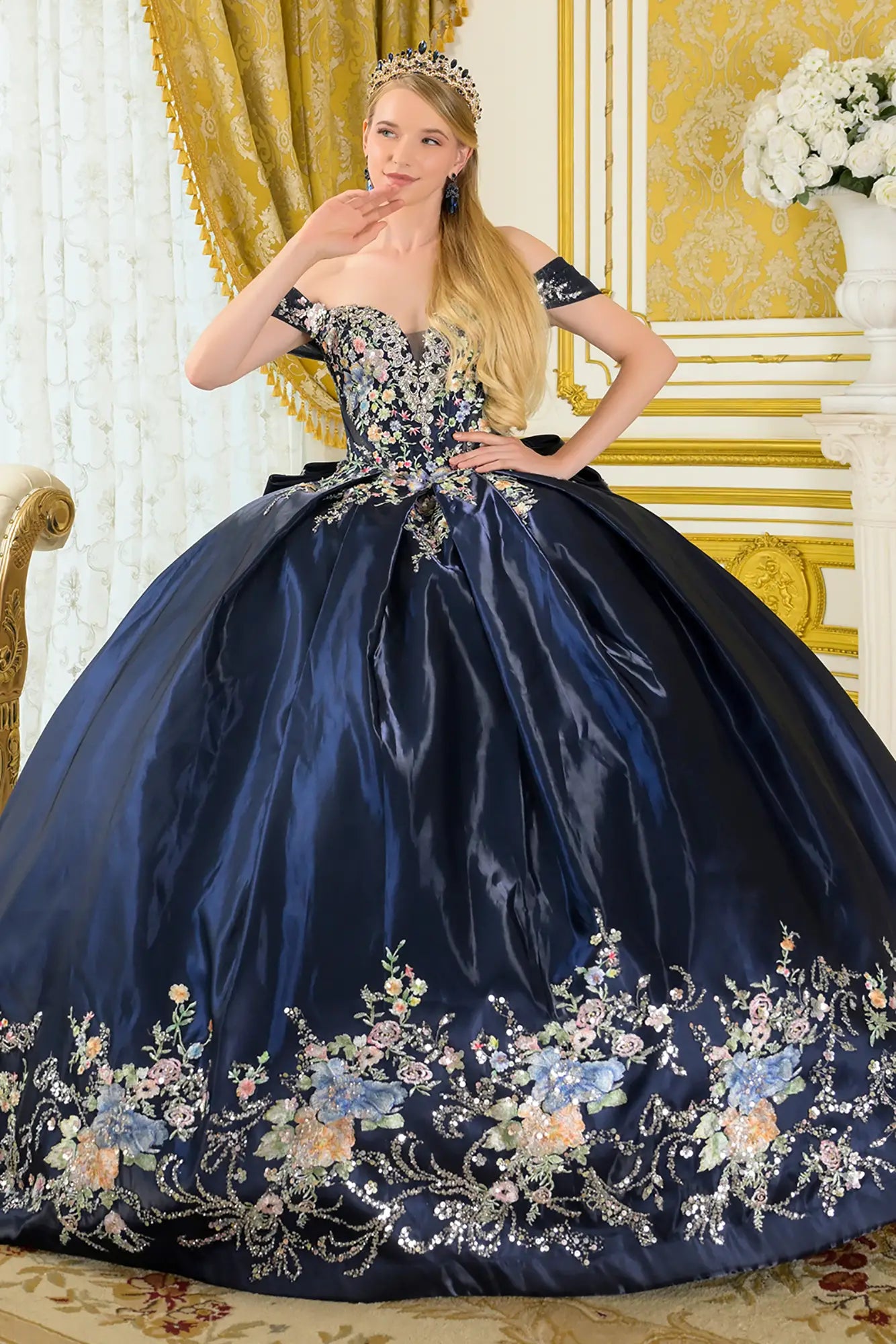 Girl wearing a navy quinceañera dress floral embroidery in an elegant room.