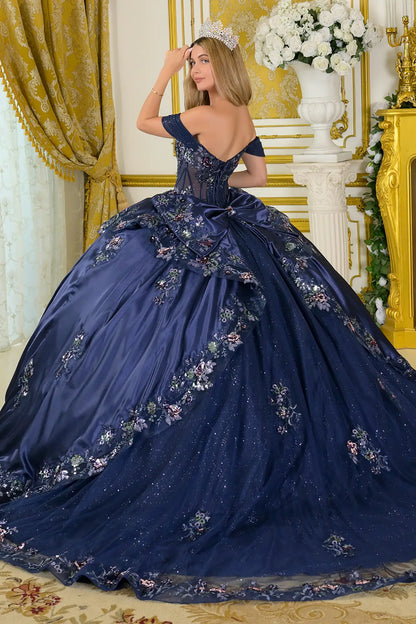 Girl wearing a navy quinceañera dress with satin-decorated bodice in a decorated room.