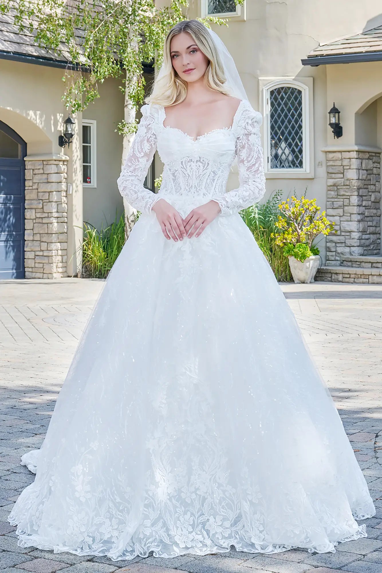 Woman in a white wedding dress standing in front of a house.