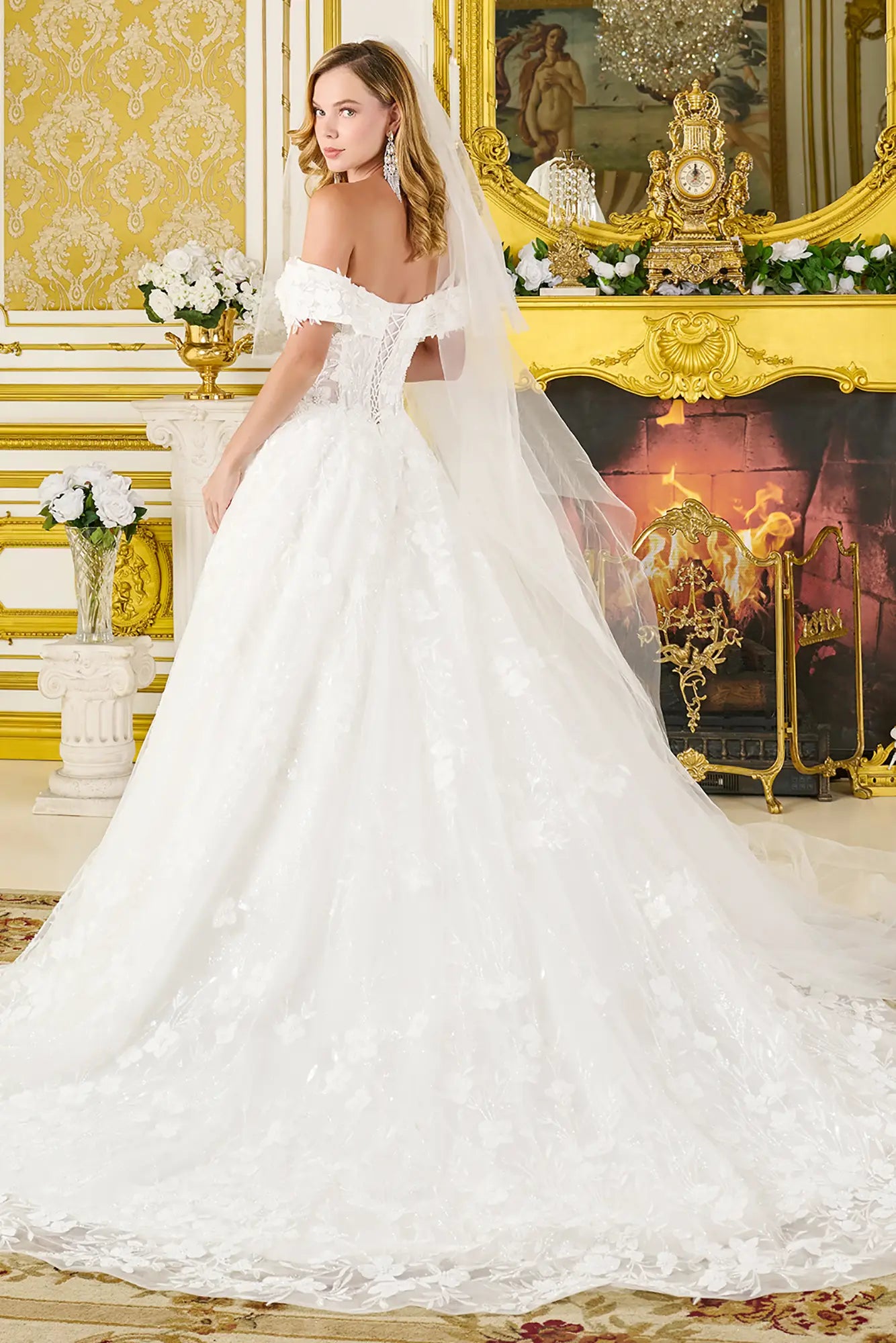 Woman in a white wedding dress with a long veil in an ornate room.