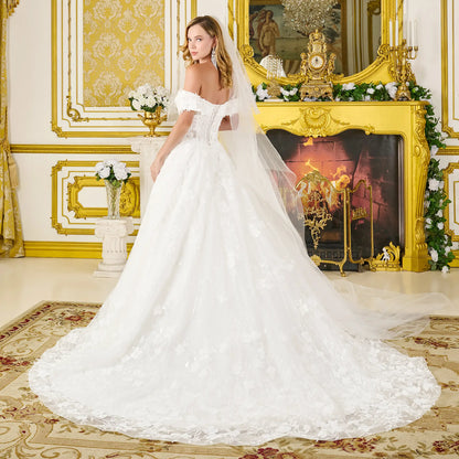 Woman in a white wedding dress standing in an opulent room with gold decor.