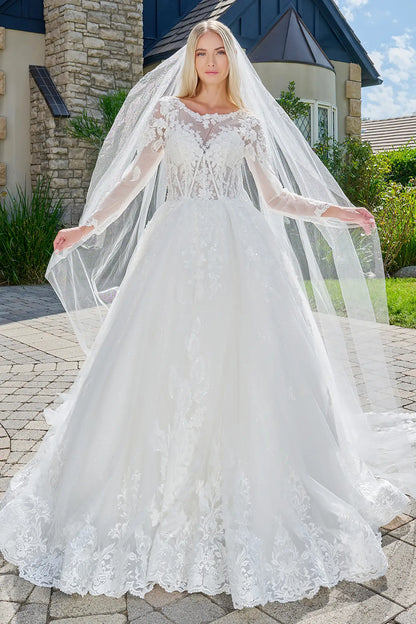 Woman wearing a white wedding dress with a long veil outdoors.