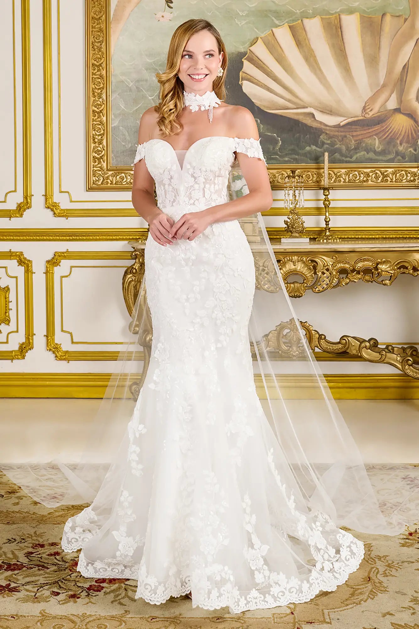 Woman in a white wedding dress standing in an ornate room with gold accents.