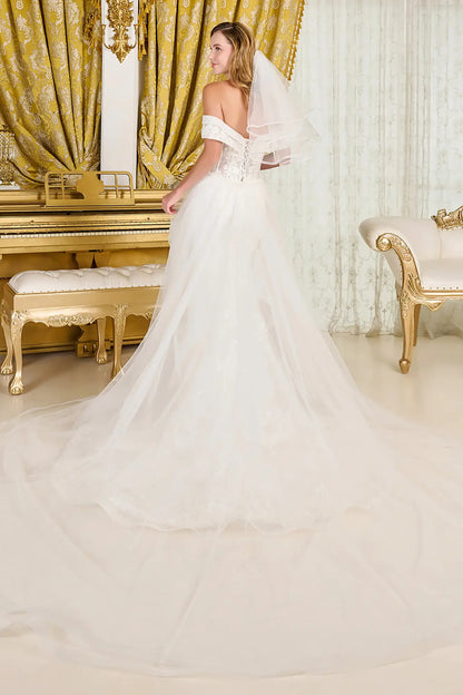 Woman in a white wedding dress with a long train in an elegant room with gold curtains and a piano.
