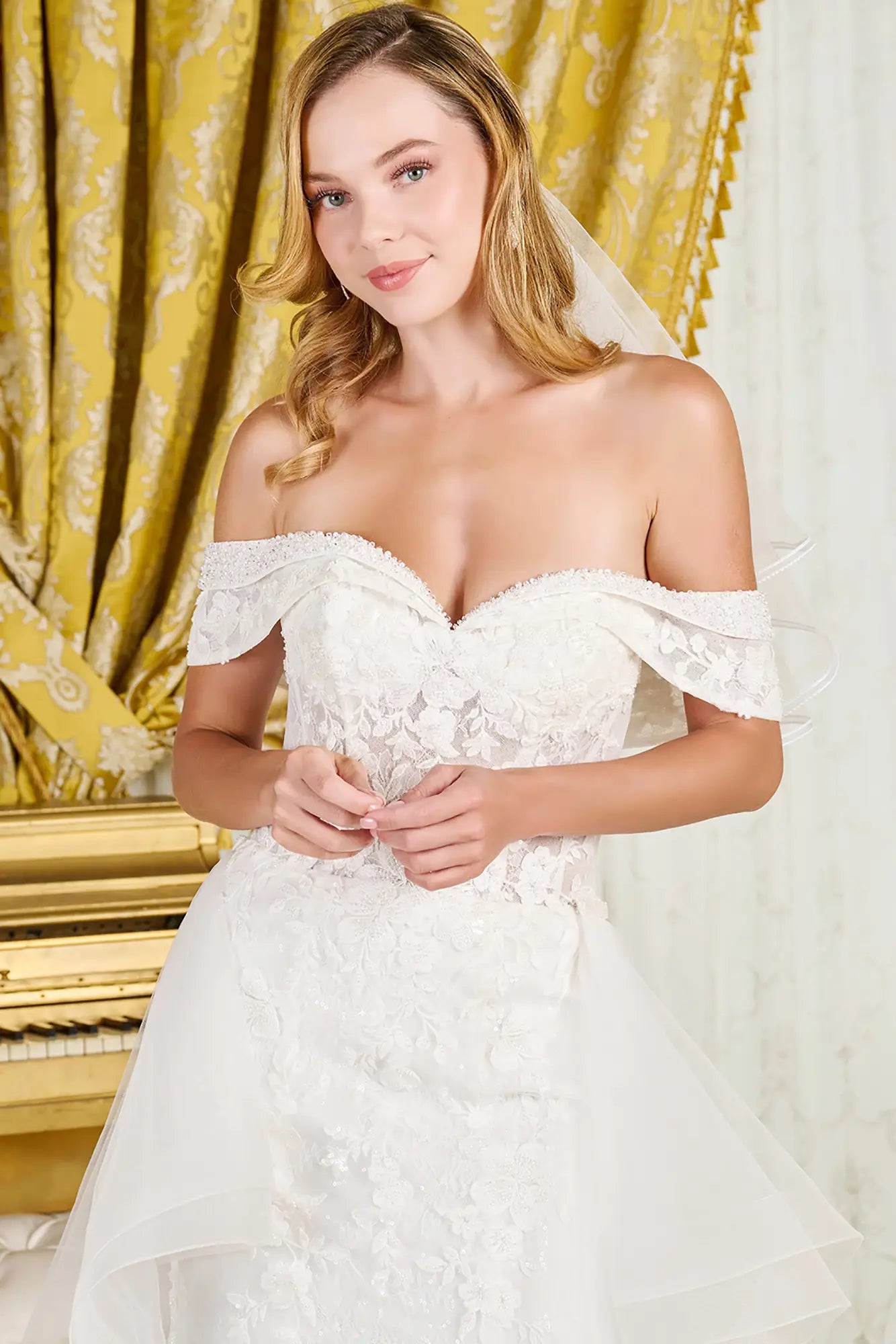 Woman in a white lace wedding dress with a gold curtain background