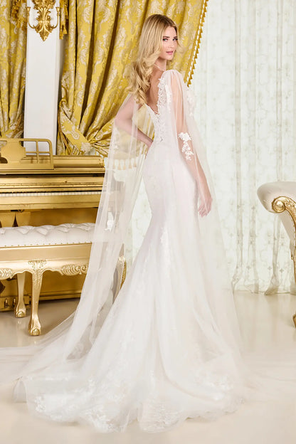 Woman in a white wedding dress standing in an opulent room with gold accents.