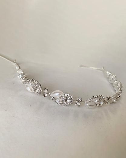 Silver headpiece with pearl and crystals on a light gray background