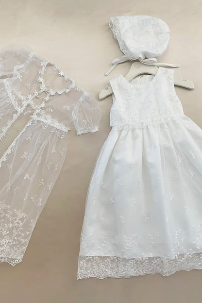 White lace dress and bonnet on a beige background